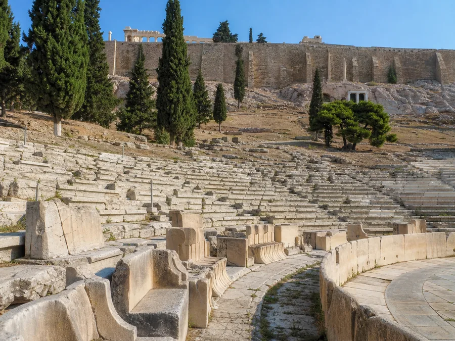 Steinsitze des Dionysostheaters am Südhang, darüber die Mauern der Akropolis